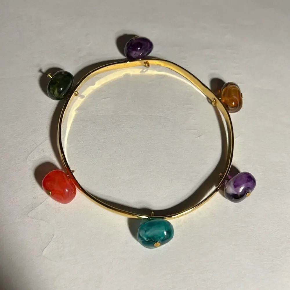 Gold tone bracelet with 6 colored gemstones.